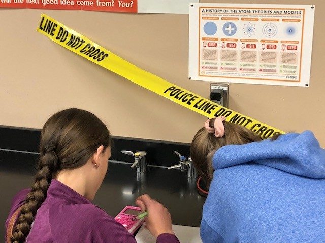 Emma and Jaylee trying to solve the mock crime.