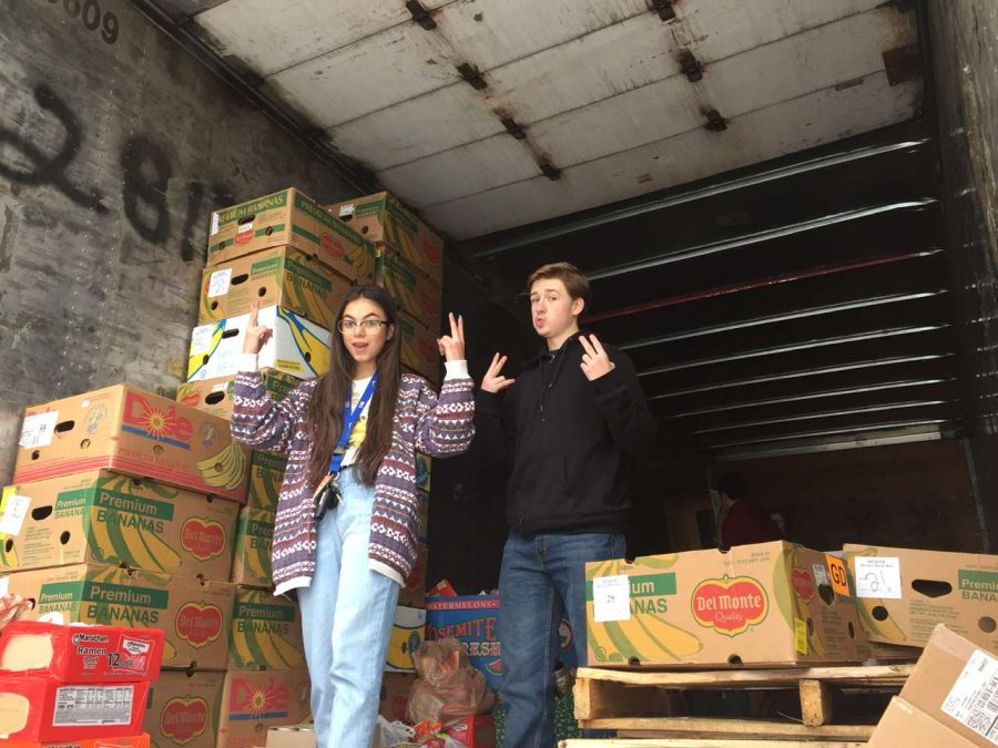Koki Davis and Michael Kirkpatrick loading food into the Harvest of Love semi-truck.