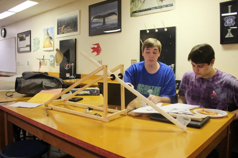 Jack Bopp and his partner modify their catapult project.