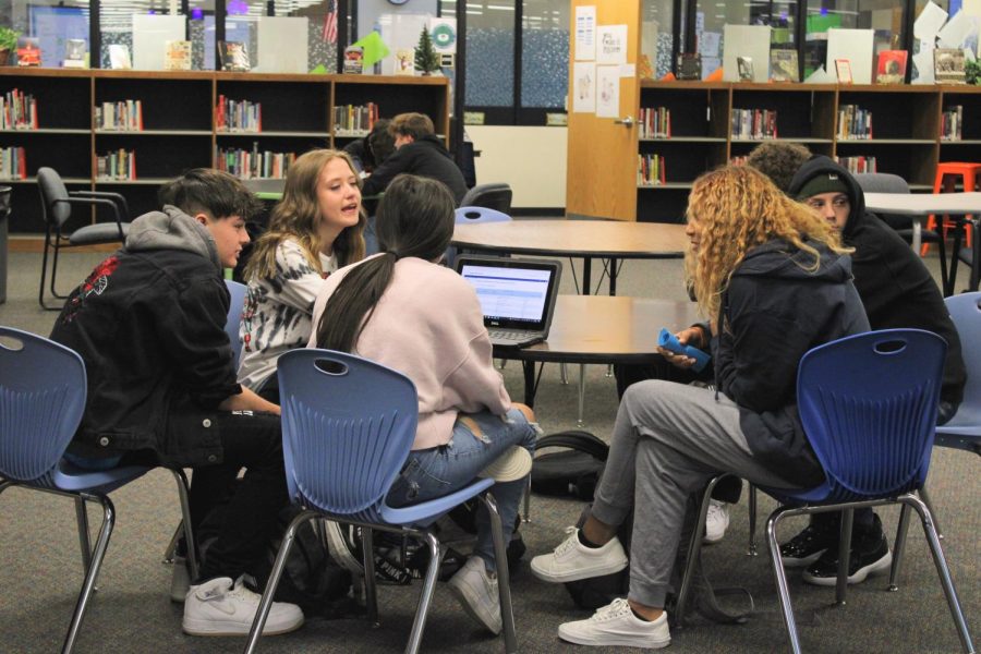 Students work together on a group project in the library during 6th period.