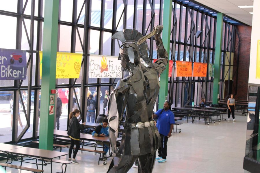 Doherty Highschool spartan staue is standing strong while one of the students is standing by it getting a picture with it 