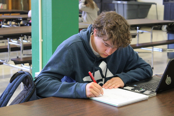 A student in the Cafeteria doing school work.