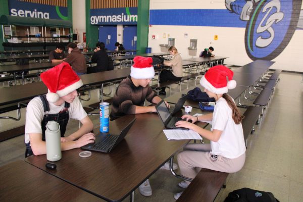 Students studying hard in the cafeteria and showing some school spirit with there santa hats