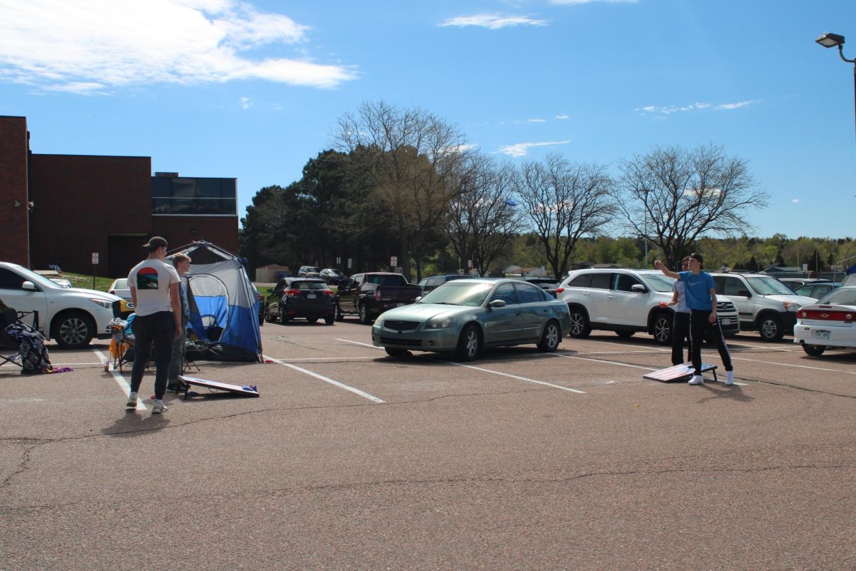 Seniors playing Cornhole in the parking lot as part of a senior prank.