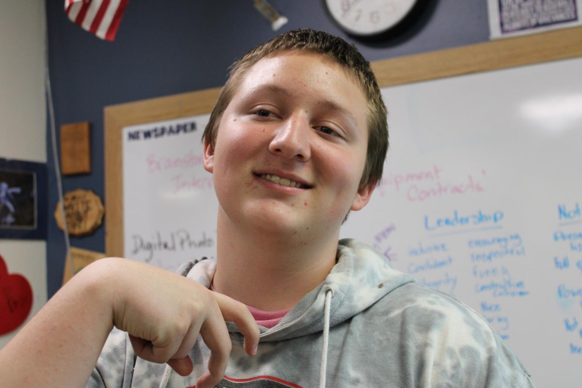 Chris Reynolds posing in his journalism class. He said, "I want more clocks around the school."