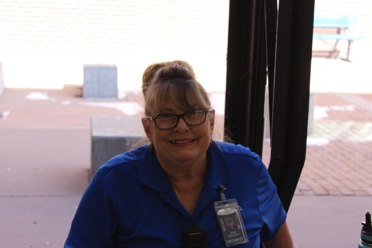 Security guard Jodee sitting at a table chatting with students waiting for class to end.