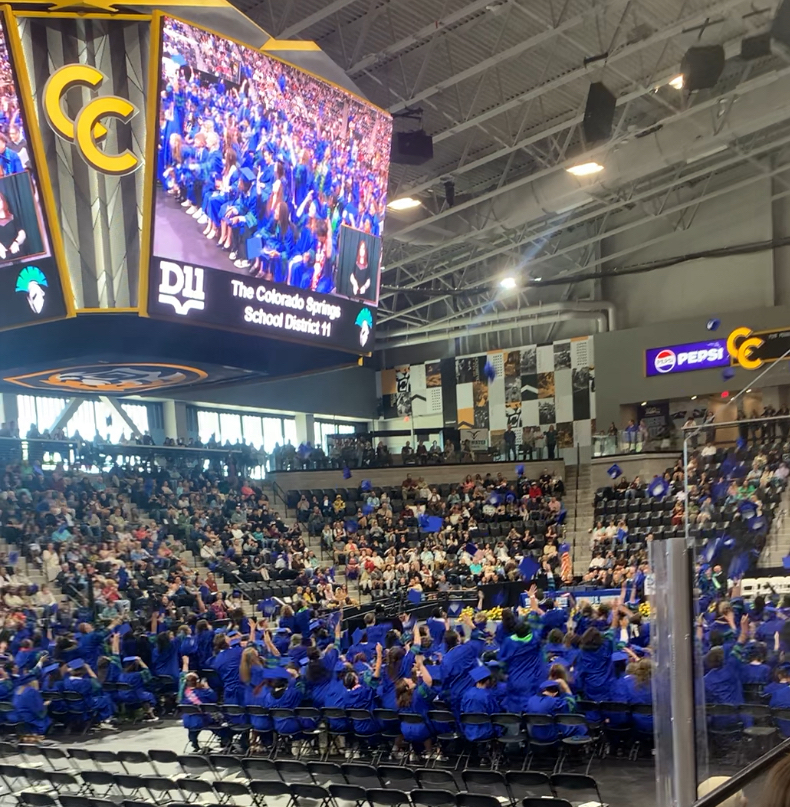 Doherty Class of 2025 throwing their caps in the air at graduation. 