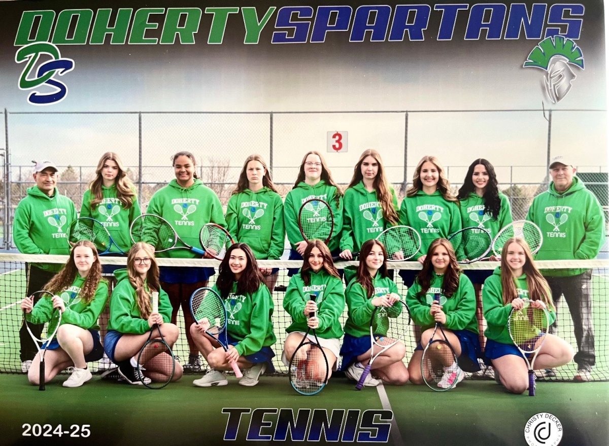 High school girl's tennis team poses with tennis rackets.