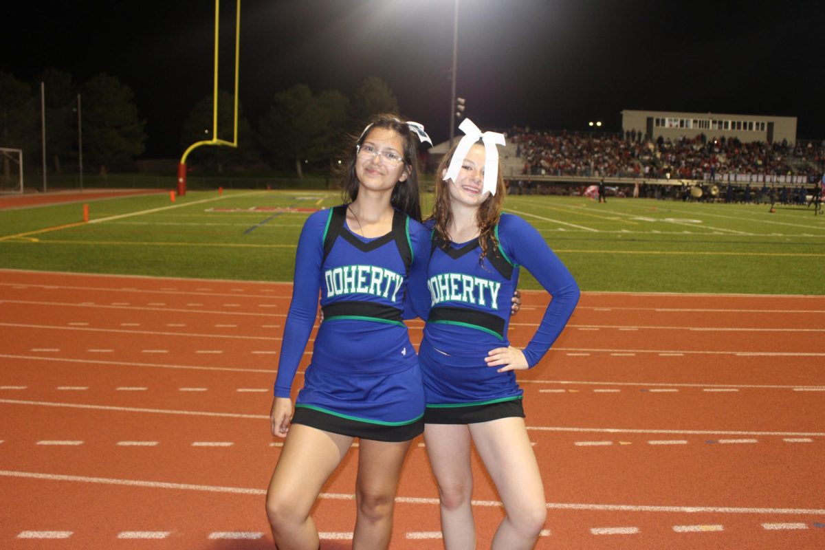 Varsity cheer leaders Eva Summers and Laila Phillips at the first football game of the year at Liberty.